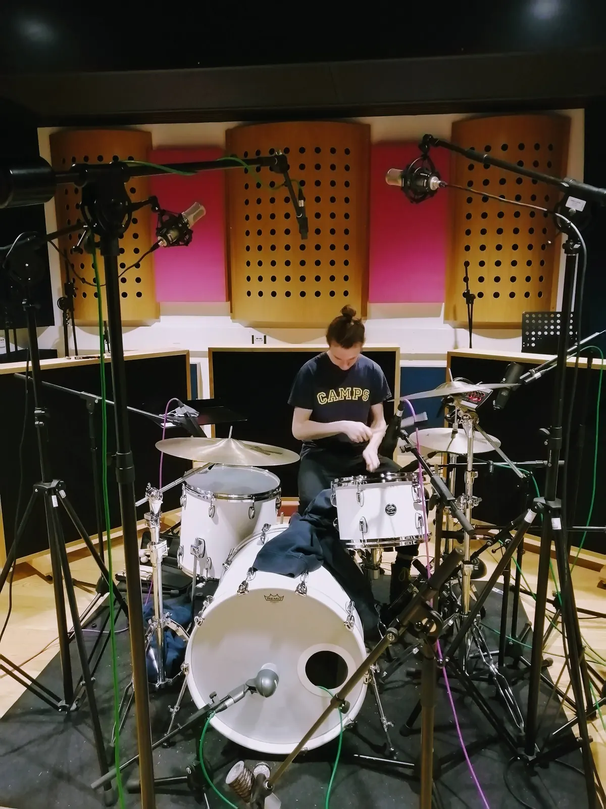 Luke Staniland at a drum kit in a recording studio live room